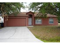 Charming single-story home featuring a two-car garage and a well-maintained front yard at 721 Waxwing Ct, Kissimmee, FL 34759