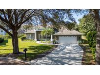 Charming single-story home with a manicured lawn, mature trees, and a two-car garage at 806 Roswell Cv, Lake Mary, FL 32746