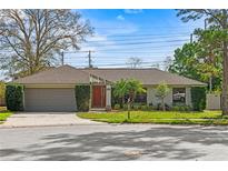 Charming single-story home with a well-maintained lawn and a two-car garage at 9360 Sonia St, Orlando, FL 32825