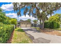 This property features a two car garage with a driveway and lush landscaping at 1213 Richmond Rd, Winter Park, FL 32789