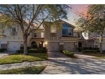 Charming townhome featuring a well-maintained lawn, two-car garage, and lovely architectural details at 124 Canterbury Bell Dr, Oviedo, FL 32765