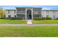 Exterior of a two-story condo building with well-maintained landscaping and screened-in balconies at 1317 S Pine Ridge Cir # 1317, Sanford, FL 32773