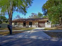 Charming single-story home featuring stone accents, a well-manicured lawn, and a driveway at 1442 S Hawthorne Ave, Apopka, FL 32703