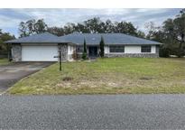 Charming single story home featuring a stone accent exterior, landscaped yard, and a two-car garage at 15683 Sw 46Th Cir, Ocala, FL 34473