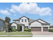 Beautifully landscaped home with a three-car garage and a well-manicured lawn at 1601 Pink Dogwood Way, Oviedo, FL 32765