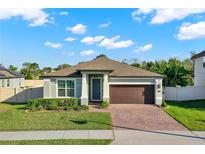 Charming single-story home features a well-manicured lawn, brick driveway, and a two-car garage at 1740 Standing Rock Cir, Oakland, FL 34787