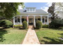 Charming two-story home with a welcoming front porch, beautiful landscaping, and a brick walkway at 2161 Snow Rd, Orlando, FL 32814