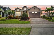 Charming two-story home featuring a manicured lawn and colorful landscaping at 4414 Azure Isle Way, Kissimmee, FL 34744