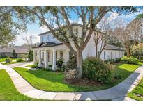 Charming home featuring a well-manicured lawn, mature trees, and beautiful landscaping at 6244 Little Lake Sawyer Dr, Windermere, FL 34786