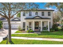 Charming two-story home with a black door, white columns, manicured lawn, and beautiful landscaping at 6244 Little Lake Sawyer Dr, Windermere, FL 34786