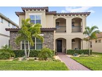 Charming two-story home featuring stone accents, a well-manicured lawn, and a welcoming front porch at 10236 Beechwood Ln, Orlando, FL 32832