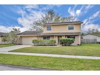 Charming two-story home featuring a brick facade, well-manicured lawn, and attached garage at 124 Cinnamon Dr, Orlando, FL 32825