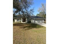 Charming single-story home with a well-manicured lawn, attached two car garage, and traditional architectural details at 13245 Sw 85Th Pl, Dunnellon, FL 34432