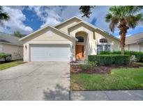 Charming single-story home featuring a manicured lawn, two-car garage, and inviting entryway at 2676 Emerald Island Blvd, Kissimmee, FL 34747