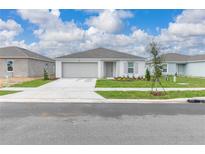 Charming single-story home with a neutral color scheme, well-manicured lawn, and a two-car garage at 304 Towns Cir, Haines City, FL 33844