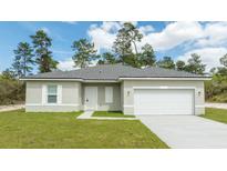 Charming single-story home featuring a two-car garage, well-manicured lawn and beautiful front yard landscaping at 3892 Sw 130Th Loop, Ocala, FL 34473