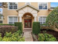 Elegant front entrance features a beautiful archway, double doors, and manicured landscaping at 8606 Terrace Pines Ct, Orlando, FL 32836
