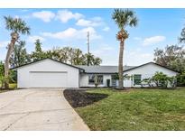 Charming single-story home with well-maintained lawn and palm trees. Two-car garage and modern exterior paint at 8908 Turnberry Ct, Orlando, FL 32819