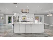 Bright, open kitchen with white cabinets, stainless appliances, and large center island at 8908 Turnberry Ct, Orlando, FL 32819