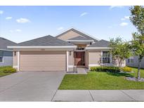 Charming single-story home featuring a two-car garage and well-manicured lawn at 1200 Kellogg Dr, Tavares, FL 32778