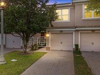 Charming townhome featuring a well-maintained yard, brick driveway, and convenient two-car garage at 1206 Bella Cara Ct, Davenport, FL 33896