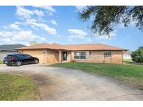 Charming single-story home with a well-manicured lawn and long driveway at 1644 Piccadilly Dr, Daytona Beach, FL 32117