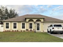 Charming single-story home with manicured lawn, arched entryway, and neutral color scheme with a newer car parked in the driveway at 203 Flounder Pl, Kissimmee, FL 34759