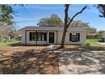 Charming single-story home with black trim, front yard with mature trees, and a welcoming entrance at 509 Nicole Blvd, Ocoee, FL 34761