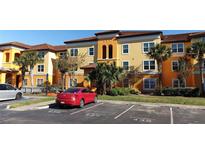 Charming condo building featuring a colorful facade, manicured landscaping, and assigned parking at 5479 Vineland Rd # 9104, Orlando, FL 32811