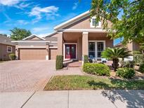 Charming single-Gathering home featuring a well-manicured lawn, a red front door, and a brick driveway and walkway at 6232 Talaria Dr, Windermere, FL 34786