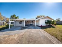 Charming single-story home featuring a carport, landscaped front yard, and a mix of stone and siding accents at 955 Tomes Ct, Orlando, FL 32825