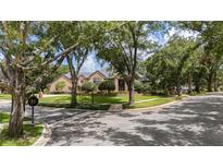 Beautiful brick home featuring mature landscaping, a circular driveway, and a welcoming front entrance at 1500 Whitstable Ct, Lake Mary, FL 32746