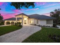 Stunning home exterior featuring a paved driveway, lush landscaping, and elegant architectural design at 2207 Cairns Ct, Orlando, FL 32835