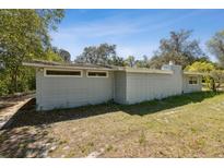 Side view of a gray block home featuring a chimney and small windows at 27630 Jean Ave, Paisley, FL 32767