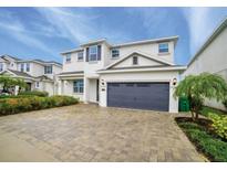 Exterior elevation showcasing a two-story home with gray shutters, a well-kept lawn, and a two-car garage at 280 Burma St, Kissimmee, FL 34747