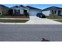 Charming single story home with a well-manicured lawn, driveway and dark blue shutters at 3166 Sweet Acres Pl, St Cloud, FL 34772