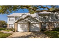 Charming townhome showcasing dual garages, brick accents, and mature trees providing ample shade at 5258 Tunbridge Wells Ln # 1902, Orlando, FL 32812