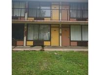 A two-story building featuring exterior walkways and colorful doors to individual units at 7900 S Orange Blossom Trl # 2052, Orlando, FL 32809