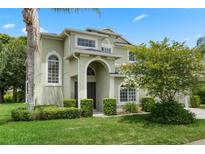 Charming two-story home with an arched entryway and lush, green landscaping, perfect for curb appeal at 901 Dorset Pl, Davenport, FL 33896