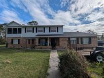 Charming two-story home featuring a brick facade, black shutters, and a well-maintained front yard at 1601 Randolph St, Deltona, FL 32725