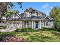 Charming two-story home with stone accents, a well-manicured lawn, and a bright blue front door at 1741 Pine Ave, Winter Park, FL 32789