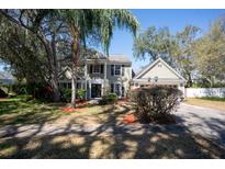 Charming two-story home with lush landscaping, mature trees and ample curb appeal on a sunny day at 1770 Nordic Ct, Apopka, FL 32712