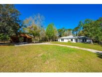 Charming single story home with a rustic barn and a well-maintained green lawn under a clear blue sky at 20773 Starry St, Orlando, FL 32833