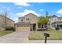 Beautiful two-story home featuring a brick driveway, attached two-car garage, and meticulously maintained landscaping at 2371 Victoria Dr, Davenport, FL 33837