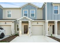 Charming home featuring a light gray and blue exterior, a one-car garage and well-maintained landscaping at 2788 Pierr St, Davenport, FL 33837