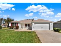 Charming single-story home features a well-manicured lawn and a two-car garage at 381 Corbett Dr, The Villages, FL 32162