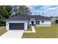 Charming one-story home with a well-manicured lawn and a two-car garage at 4914 Sw 147Th Loop, Ocala, FL 34473
