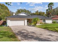 Attractive home featuring a two-car garage and a brick-accented entrance, complemented by mature landscaping at 6339 Coopers Green Ct, Orlando, FL 32819