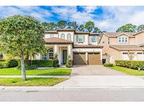 Beautiful two-story home featuring a three-car garage, landscaped yard, and a mix of stucco and stone accents at 6926 Trellis Vine Loop, Windermere, FL 34786