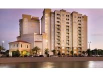 Beautiful exterior view of a resort hotel with a variety of palm trees and a row of parked cars at 7395 Universal Blvd # 104, Orlando, FL 32819